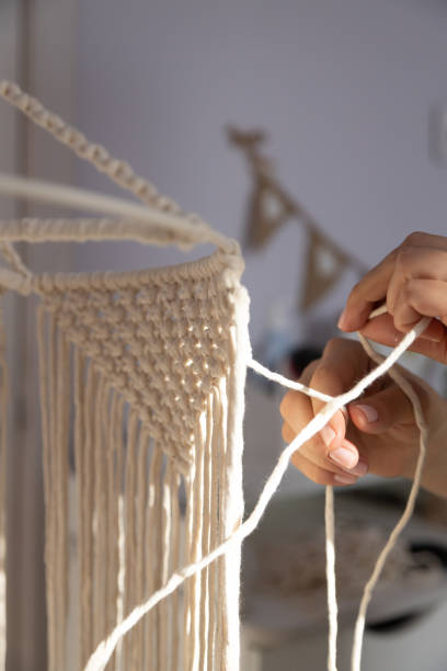 istock closeup weaving of macrame threads , women's hands 1352298763