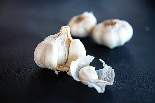 Garlic bulbs on black background.