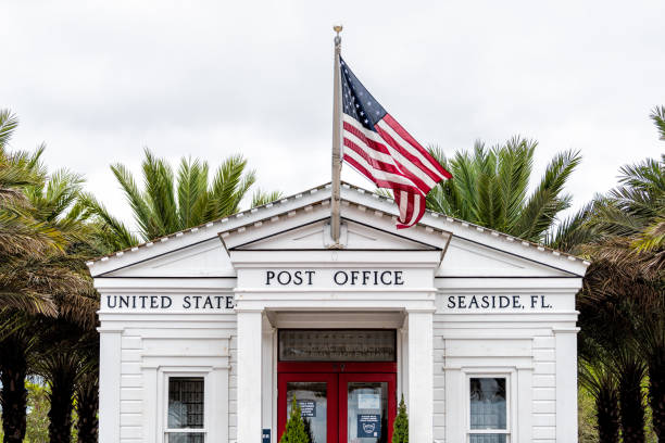 Town in Florida panhandle with Post Office sign in city town beach gulf of mexico, white architecture new urbanism and American flag Seaside, USA - January 9, 2021: Town in Florida panhandle with Post Office sign in city town beach gulf of mexico, white architecture new urbanism and American flag new urbanism stock pictures, royalty-free photos & images
