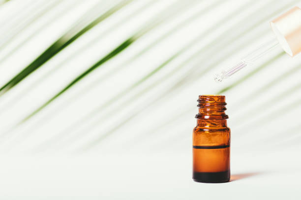 istock Essential oil dripping from pipette to bottle 1352299082