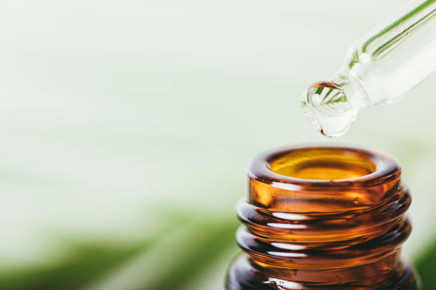 istock Natural essential oil drop from pipette into bottle 1352299105