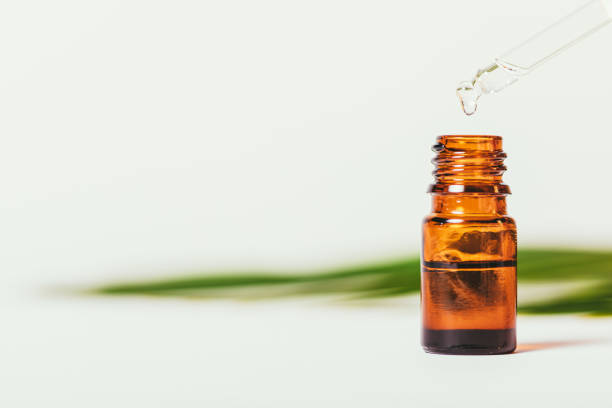 istock Drop organic essential oil drips into dark glass bottle 1352299160