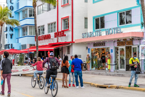 south beach célèbre rue ocean drive avec des bâtiments rétro art déco colorés multicolores bleus et rouges et de nombreuses personnes par les hôtels - colony photos et images de collection