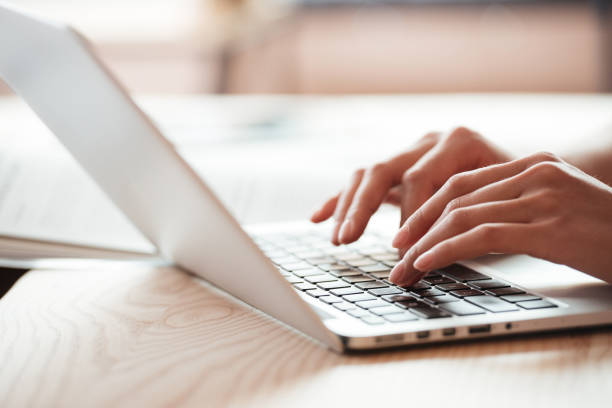 istock Cropped image of young woman indoors using laptop computer 1352300336