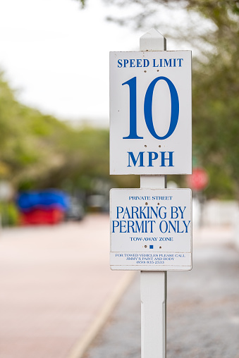 Seaside, USA - January 10, 2021: Closeup of small town residential street road sign for speed limit 10 miles hour by beach in Florida panhandle gulf of mexico