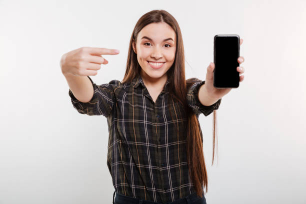 istock Woman in shirt showing blank smartphone screen 1352302111