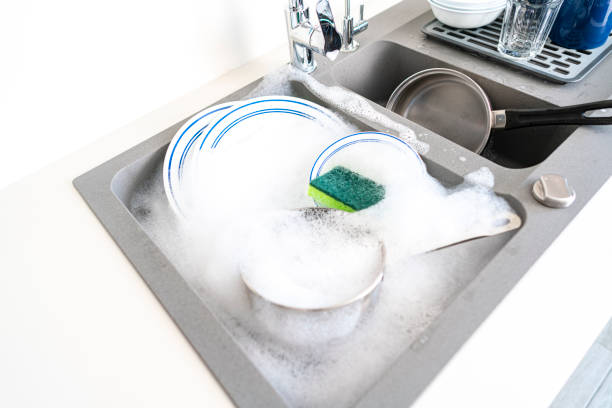 istock Dirty dishes in a modern kitchen sink 1352302457
