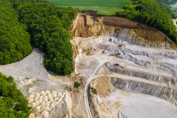 istock Open pit mining of construction sand stone materials with excavators and dump trucks. 1352305380