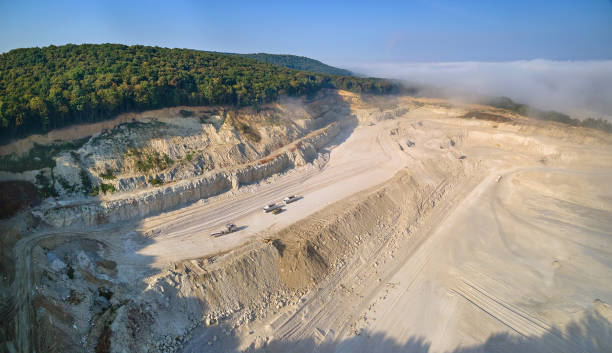 istock Aerial view of open pit mining site of limestone materials extraction for construction industry with excavators and dump trucks. 1352305400