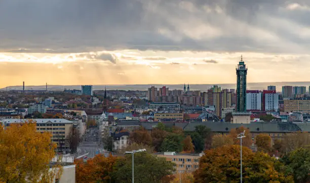 A picture of the Ostrava New City Hall, the nearby buildings and the foliage in the fall.