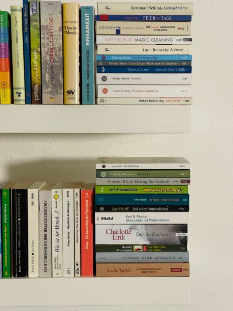 istock Stacks of books on white shelves 1352308515