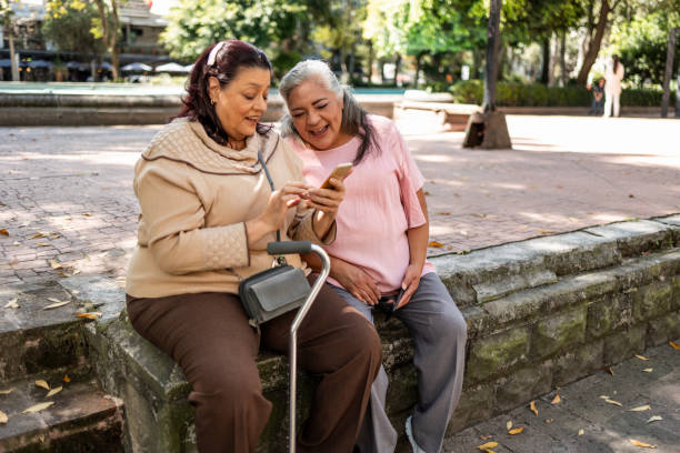 Two senior Hispanic women using mobile phone