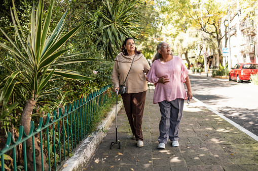 Two senior women walking and talking