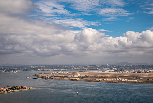 San Diego, California, USA - October 5, 2021: Naval air station. on North Island  with some skyline seen from Cabrillo National Monument under heavy blue cloudscape. Bay of Parcific Ocean up front.