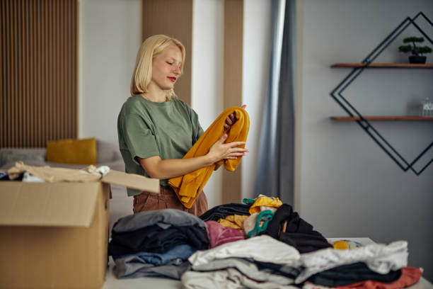 istock Woman putting clothes inside donation box 1352314746