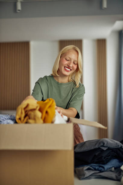 istock Woman sorting clothes for donation 1352314787