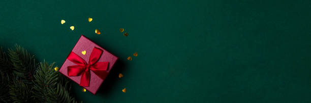 istock Red gift box with sequins on a green background Holiday gift for Christmas 1352315934