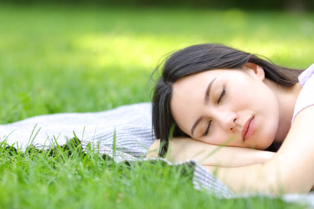 istock Asian woman sleeping lying on the grass 1352315977