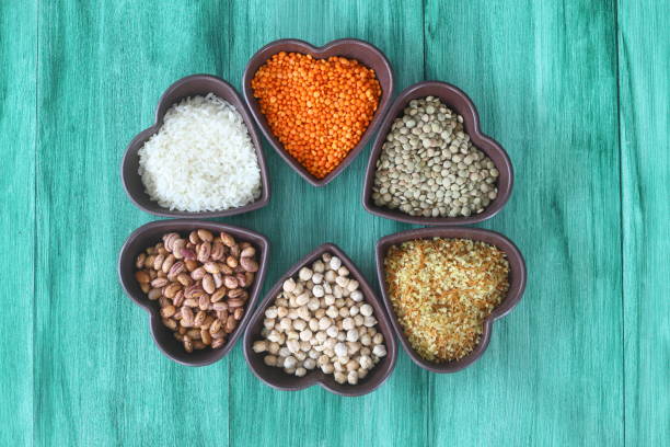 Different type of raw dry legumes composition. White Rice, lentils, red lentils, chickpeas and kidney beans. Mix organic legume concept. With Heart shape bowl. Different type of raw dry legumes composition. White Rice, lentils, red lentils, chickpeas and kidney beans. Mix organic legume concept. With Heart shape bowl. red mung bean stock pictures, royalty-free photos & images