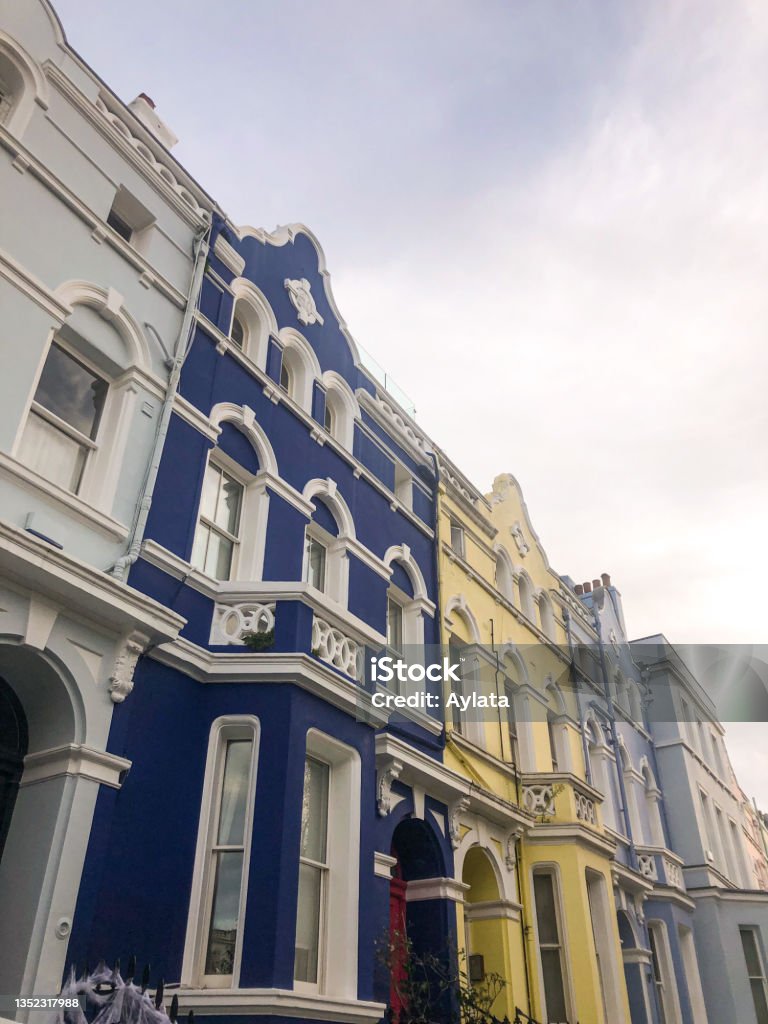 Colourful houses of Notting Hill in London Colourful houses of Notting Hill in London, bright and shiny in the daylight and beautiful sky above. These are pieces of architectural beauty, examples of cozy living Facade Stock Photo