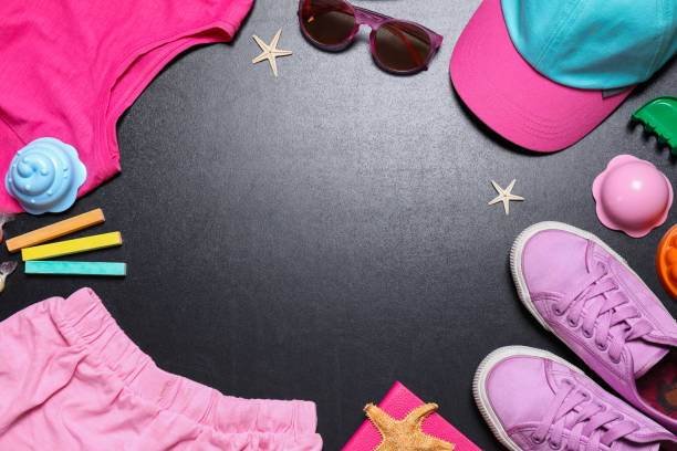 istock Frame of child's clothes on blackboard, space for text. School holidays 1352319280