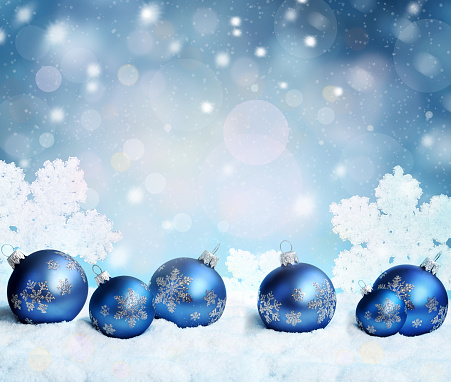 Beautiful blue Christmas balls, snowflakes on snow and winter background.