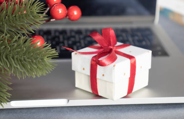 istock Gift Box With Red Ribbon On Black Laptop Keyboard 1352320784
