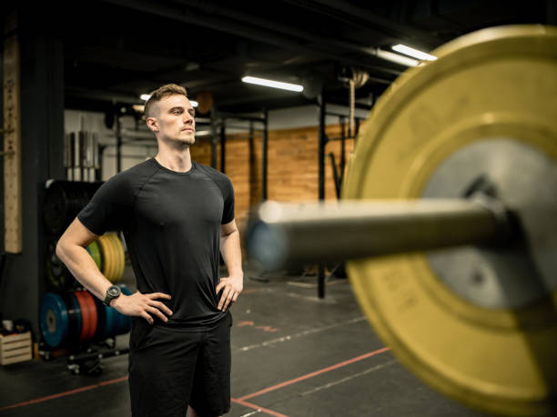 istock Young Man lifting weights in the Gym 1352320893