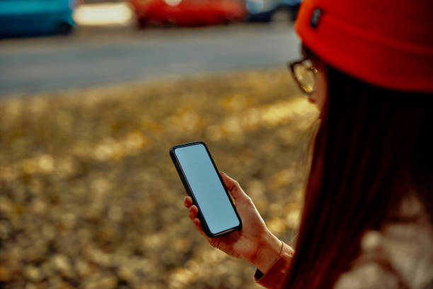 istock Woman typing on cellphone outdoors 1352321045