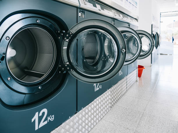 fila de máquinas de lavar em uma lavanderia pública. - laundromat clothes washer laundry utility room - fotografias e filmes do acervo