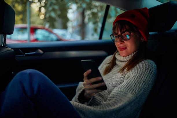 istock Young woman messaging from taxi 1352321869