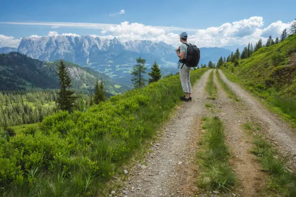 Traveler man on hiking trail enjoying Wilder Kaiser mountains, Tirol - Austria.