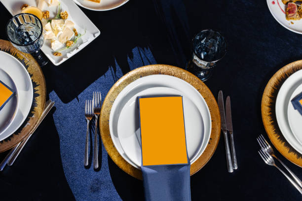 istock Restaurant empty menu mock up. Festive table setting with blue silk ribbon and gold pads. Festive wedding, birthday table setting. 1352323693