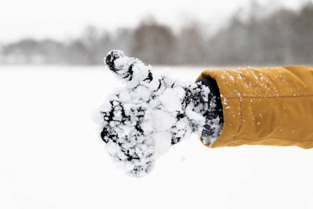 Hand in snowy glove showing thumb up on white background