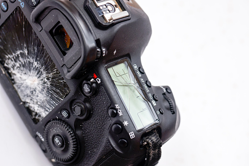 Damaged DSLR camera, broken screens, background with copy space, full frame horizontal composition