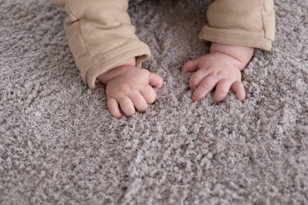 istock hands of baby crawling on floor or carpet 1352326197