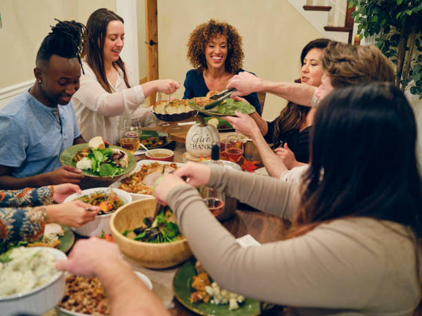 friends celebrating thanksgiving dinner together - eating people group of people home interior imagens e fotografias de stock