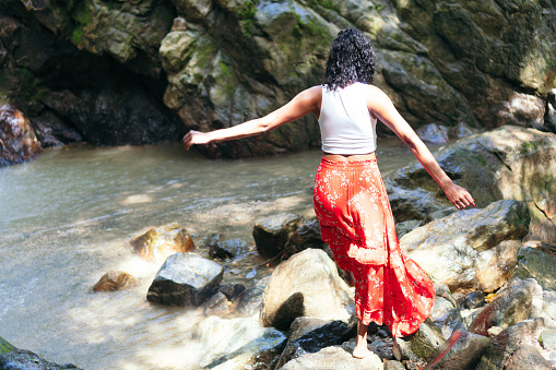 Latin Woman Standing By Waterfall. Vacation and Tourism Concept