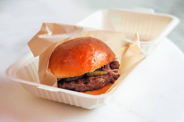 Food delivery, burger in a white plastic container. Traditional classic american restaurant or bar menu