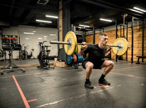 istock Young Man lifting weights in the Gym 1352332896