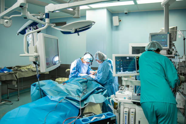 sala operatoria, i chirurghi eseguono un'operazione, un team di chirurghi professionisti che lavorano in sala operatoria con attrezzature moderne - general practice foto e immagini stock