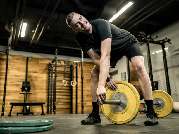 istock Young Man lifting weights in the Gym 1352333375