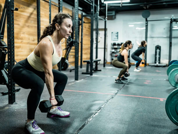 istock Women lifting weights in the Gym 1352333566