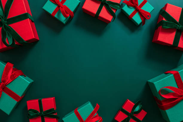 marco de regalos sobre un fondo verde. decoraciones navideñas o festivas. cajas de regalo verdes y rojas. espacio de copia, vista superior, colocación plana. - regalo de navidad fotografías e imágenes de stock