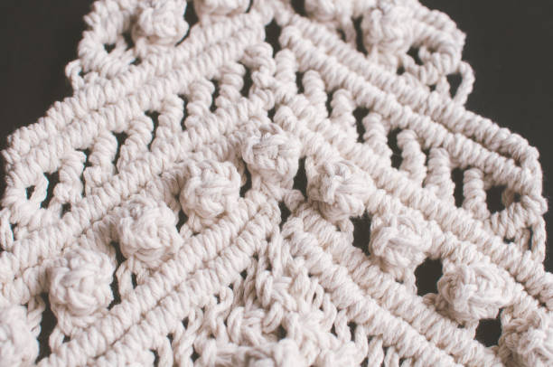 istock Macrame ornament from white natural cotton threads on a black background. 1352339880