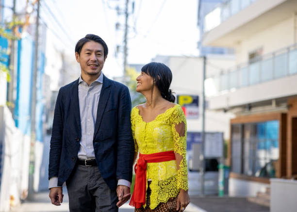 インドネシアと日本のカップルが一緒に街を歩く - mid adult couple ストックフォトと画像