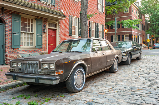 A 1980s Plymouth Gran Fury is parked on a street in the Old City district of Philadelphia, Pennsylvania, USA in the evening.