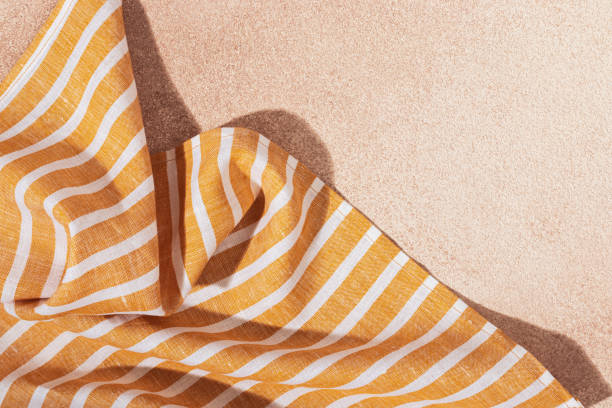 istock Striped textile yellow serving napkin on beige plastered backdrop 1352346821