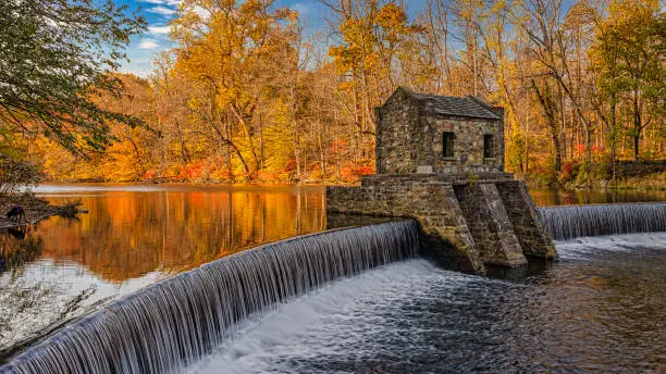 An autumn view of the historic dam at Speedwell Lake in Morristown, New Jersey.