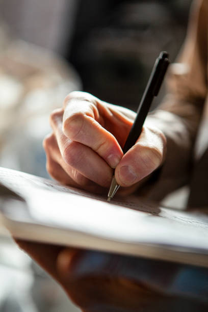 istock Close-up of man hand writing on clipboard 1352362724